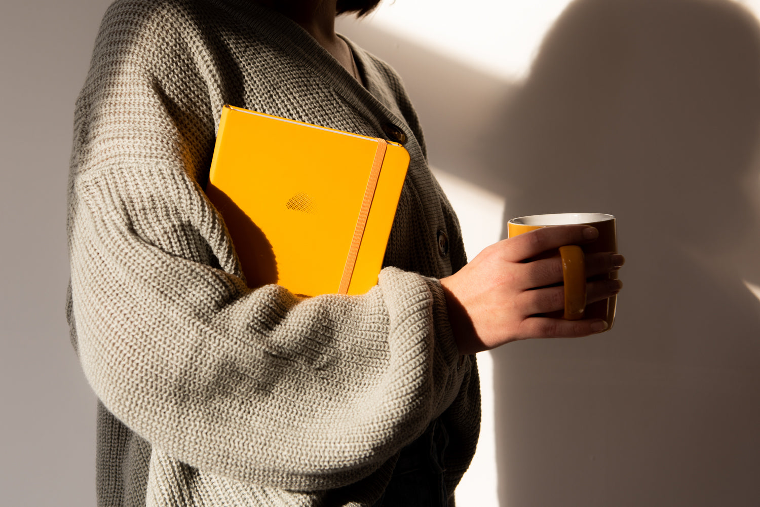 woman holding yellow notebook