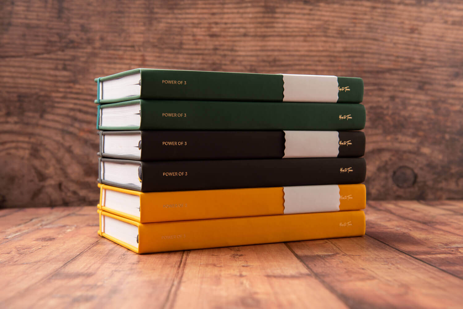 Stack of 6 goal planners on wooden surface.