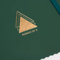 Close up of Power of 3 goal planner gold emblem on forest green cover