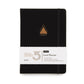 Front on shot of power of 3 goal planner in charcoal showing gold triangle emblem and paper sleeve