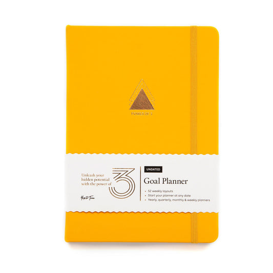 Front on shot of power of 3 goal planner in sunshine yellow showing gold triangle emblem and paper sleeve